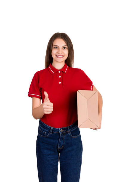 Молодая красивая женщина держит коробку посылки указывая большой палец вверх изолированы на белом фоне
 - Фото, изображение
