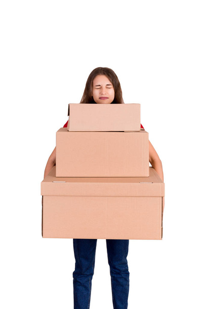 Tired delivery woman is holding a stack of heavy cardboard boxes. Pretty girl is exhausted after hard day isolated on white background - Photo, Image