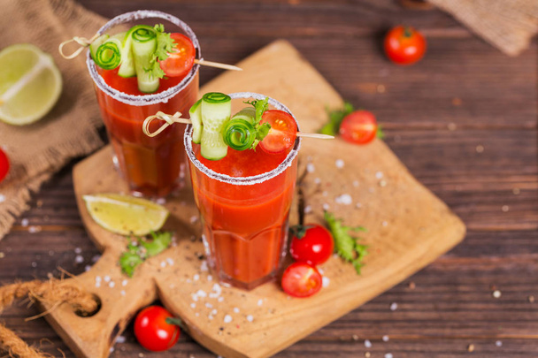 Two glasses of tomato juice decorated with fresh tomatoes, cucum - Foto, afbeelding