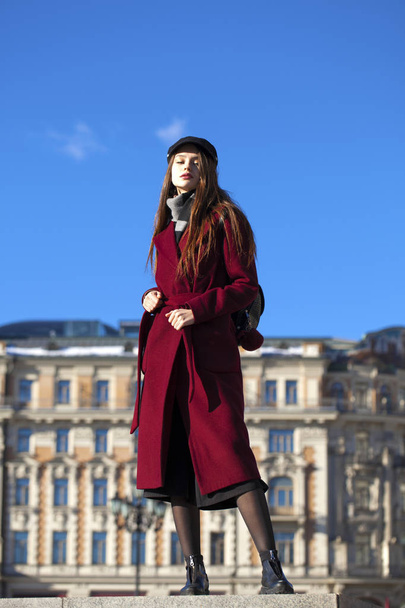 Beautiful girl in stylish in a long burgundy coat - 写真・画像