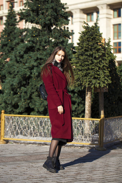 Beautiful girl in stylish in a long burgundy coat - Fotó, kép