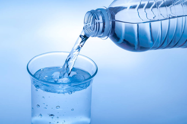 garrafa de água potável e derramamento de água em vidro em b abstrato
 - Foto, Imagem