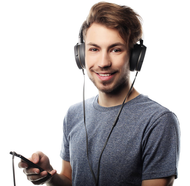 Man holding mobile phone and lictening to music over white backg - Photo, image