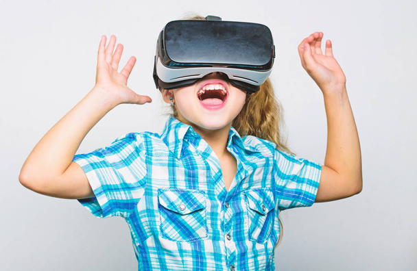 Girl cute child with head mounted display on white background. Virtual reality concept. Small kid use modern technology virtual reality. Virtual education for school pupil. Get virtual experience - Photo, image