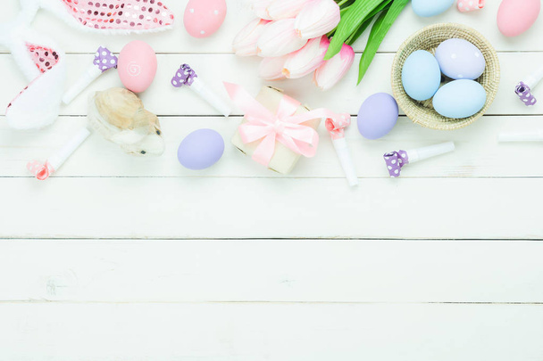 Table top view shot of decorations Happy Easter holiday background concept.Flat lay bunny eggs with tulip and variety decor for season on modern rustic white wooden.Blank space design for mock up. - Fotó, kép