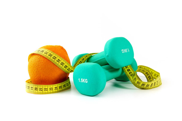 healthy eating and active lifestyle concept - dumbbells with orange and measuring tape - Фото, зображення