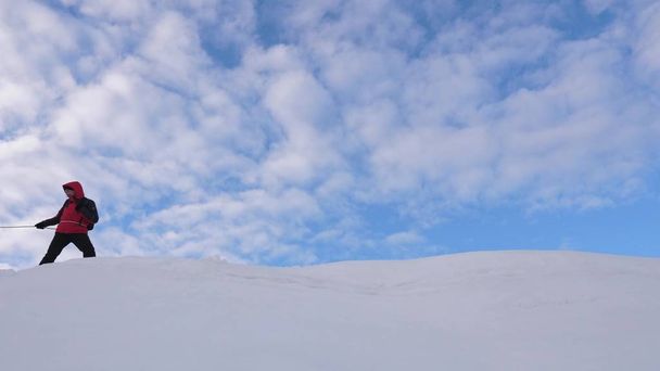 Mit Seilen gebundene Bergsteiger folgen einander entlang des schneebedeckten Grats. Team von Reisenden im Winter auf den Gipfel des Berges zu gehen. Gut koordinierter Teamwork-Tourismus im Winter - Foto, Bild