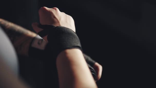 athlete pulls on his wrists protective bandages before boxing training - Footage, Video