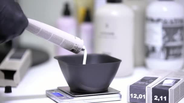 Stringere la vernice per capelli nel piatto nero, lavorando in guanti neri
 - Filmati, video