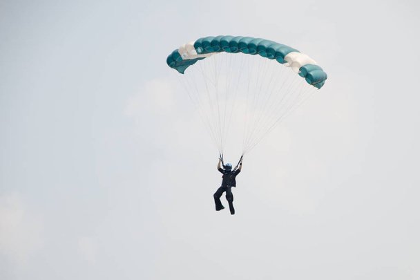 Парашютист на голубом небе готовится к посадке
 - Фото, изображение