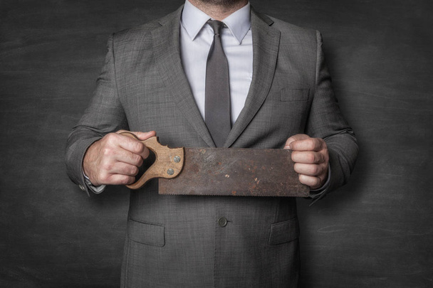 Businessman holding vintage saw - Φωτογραφία, εικόνα