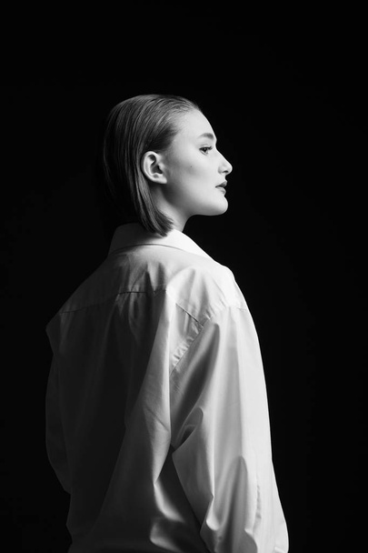 Портрет элегантной молодой женщины в белой рубашке и черном папе
 - Фото, изображение