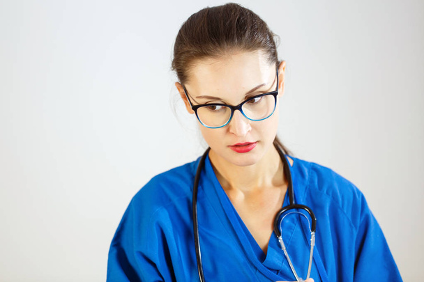 junge Ärztin in blauem Mantel und mit Stethoskop - Foto, Bild