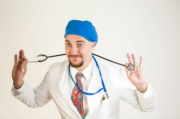 De arts is plezier hebben en houden van een stethoscoop. Close-up, witte achtergrond - Foto, afbeelding