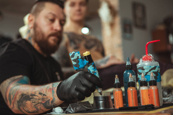 Profesjonalny tatuaż artysta robi nowy tatuaż dla jego klienta - Zdjęcie, obraz