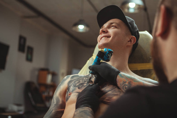 Handsome man getting a tattoo at alternative art studio - Photo, Image