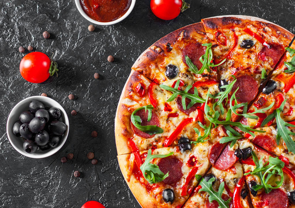 Pepperoni Pizza with Mozzarella cheese, salami, Tomatoes, olive, pepper, Spices and Fresh arugula. Italian pizza on dark background - Fotoğraf, Görsel