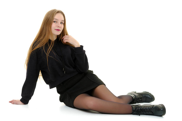 A teenage girl is sitting on the floor. - Valokuva, kuva