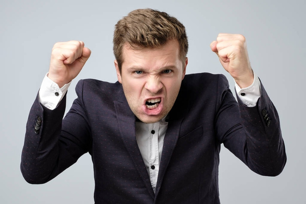 Anger crazy handsome man in suit standing shouting or screaming - 写真・画像