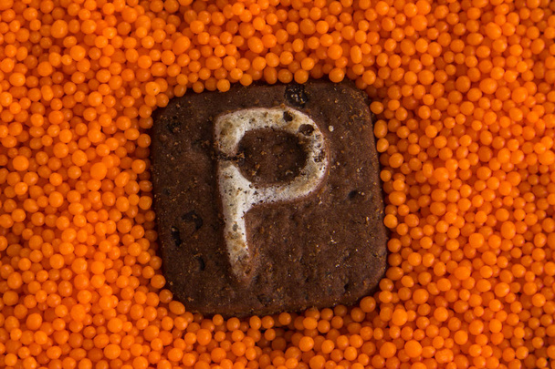 biscoitos com letras no fundo de bolas doces de laranja
 - Foto, Imagem