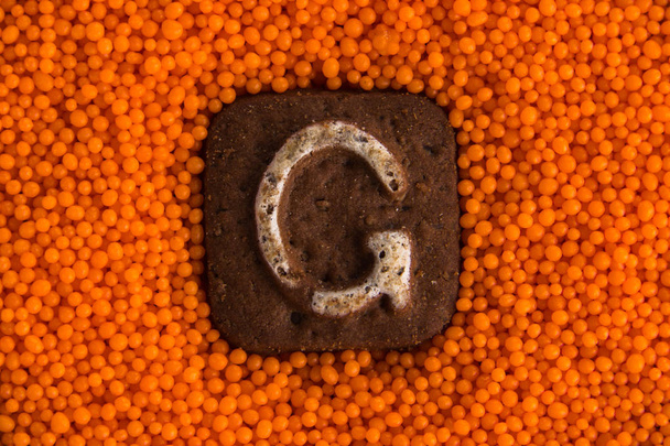 biscotti con lettere sullo sfondo di palle dolci arancioni
 - Foto, immagini