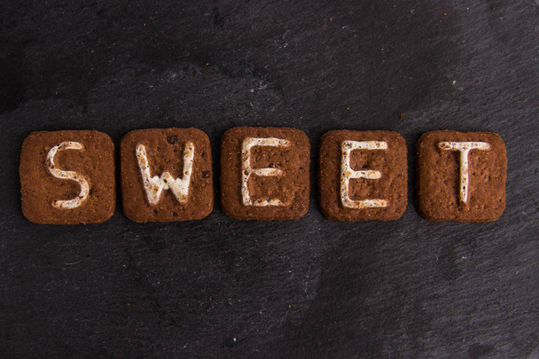 The word SWEET laid out with cookies letters - Photo, Image