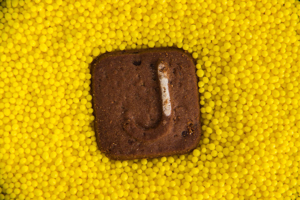 letras del alfabeto inglés sobre el fondo de bolas amarillas dulces
 - Foto, imagen