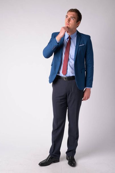 Full body shot of businessman in suit thinking - Фото, изображение