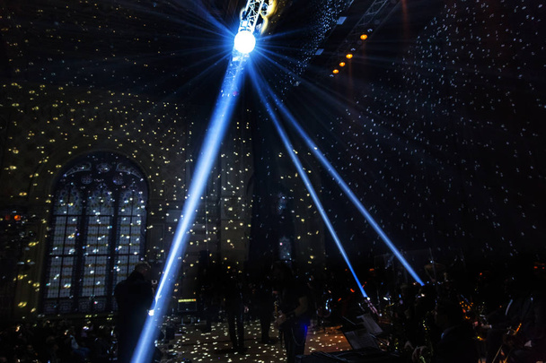 Bühnenbeleuchtung. Mehrere Projektoren im Dunkeln. Bunte Lichtstrahlen von den Bühnenscheinwerfern auf der Bühne im Rauch zur Zeit der Unterhaltungsshow. Nachtclub. Lichtershow. Faule Show - Foto, Bild