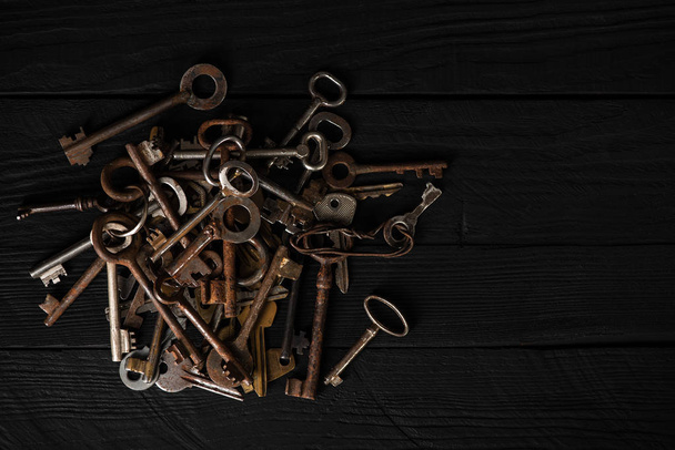 Banda starých kovových klíčů na stůl, pohled shora, nízké klíč. Téma shromažďování, vintage dekorace, bezpečnostní koncepce - Fotografie, Obrázek
