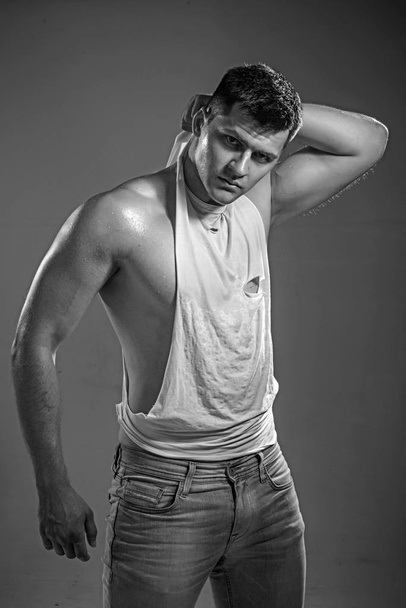 Portrait of handsome man in tank top and jeans - Фото, изображение
