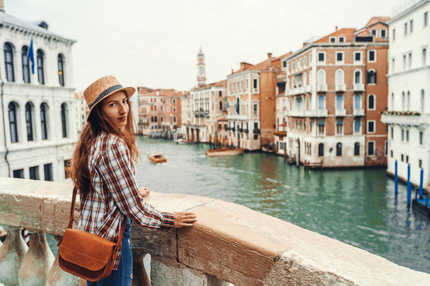 Γυναίκα στη Βενετία, στέκεστε πάνω στην γέφυρα πάνω στο μεγάλο κανάλι, ενώ σχετικά με τα αξιοθέατα σε μια ξένη πόλη. Η περιπέτεια της Βενετίας ανακάλυψη. - Φωτογραφία, εικόνα