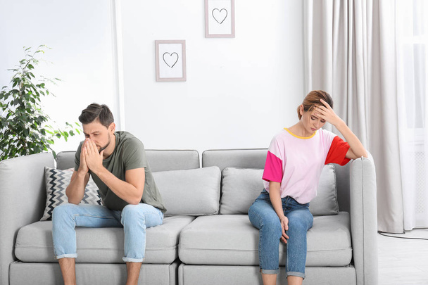 Couple ignoring each other after argument in living room. Relationship problems - Foto, Bild