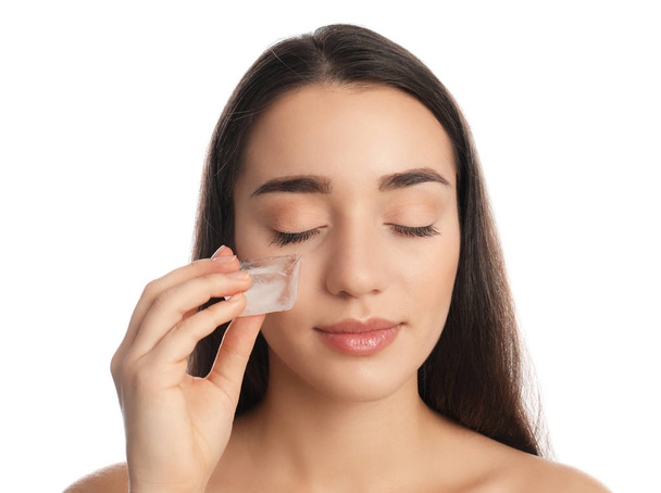 Young woman with ice cube on white background. Skin care - Φωτογραφία, εικόνα