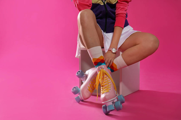 Young woman with retro roller skates on color background, closeup. Space for text - Φωτογραφία, εικόνα