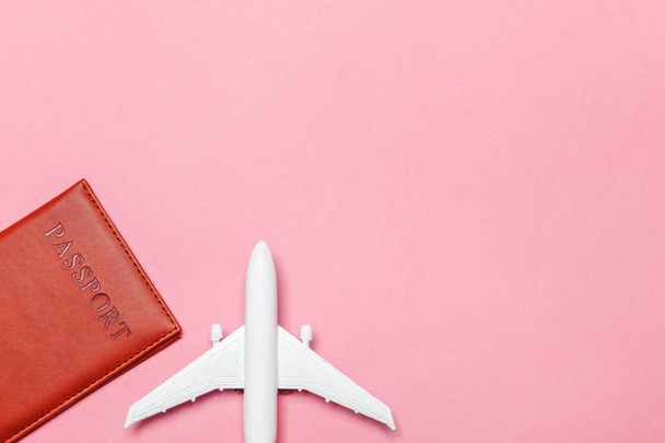 Mínimo simple plano lay viaje aventura concepto de viaje con avión y pasaporte en rosa pastel moderno fondo de moda
 - Foto, imagen