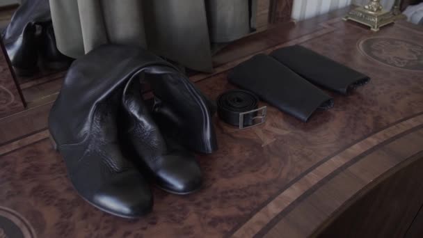 leather vintage mens boots stand on a bedside table with a mirror. - Footage, Video