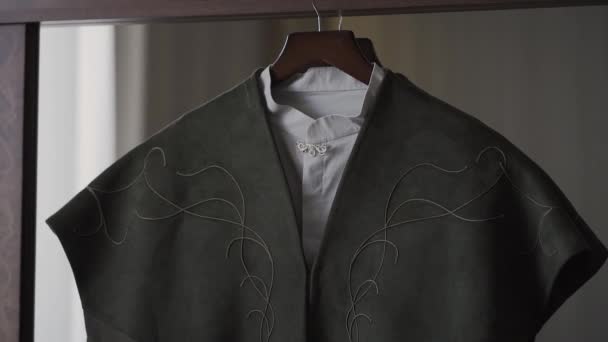 A mans jacket hangs on a hanger in the room. - Footage, Video