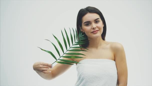 Beautiful young woman with perfect skin and natural make up posing front of plant tropical green leaves background with fern. Young model with wet hair care of her face and body. - Filmmaterial, Video