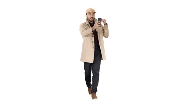 Herfst mode stijl man opname video blog wandelen op witte achtergrond. - Foto, afbeelding