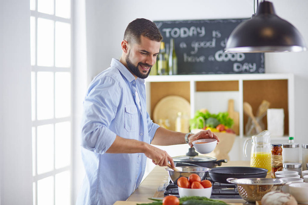 Smiling and confident chef standing in large kitchen - Photo, Image