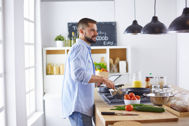 Mosolygós és magabiztos séf áll a nagy konyhában - Fotó, kép