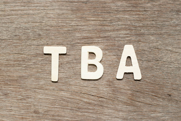 Letra del alfabeto en la palabra TBA (abreviatura de a anunciar) sobre fondo de madera - Foto, Imagen