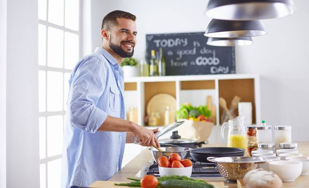 Chef souriant et confiant debout dans une grande cuisine - Photo, image