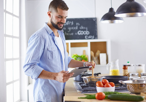 Lächelnder und selbstbewusster Koch steht in großer Küche - Foto, Bild