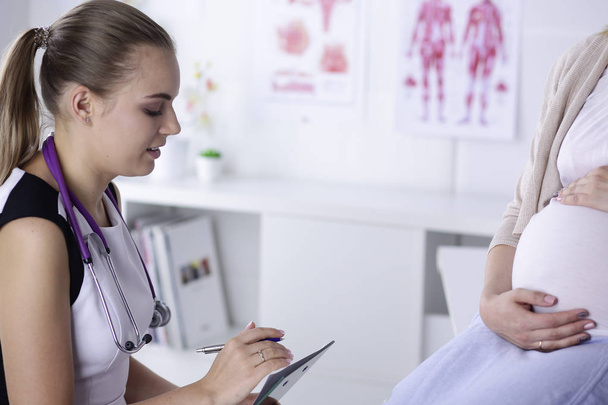 Frauenärztliche Beratung. Schwangere mit ihrem Arzt in Klinik - Foto, Bild