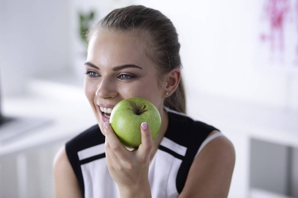Молода красива усміхнена дівчина з зеленим яблуком в руках
 - Фото, зображення