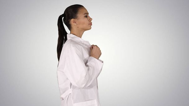 Young woman pharmacist in white gown coat uniform walking on gradient background. - Fotó, kép