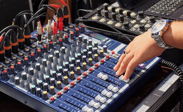 Professional mixing console with faders and adjusting knobs. The hand adjusts the sound. - Photo, Image