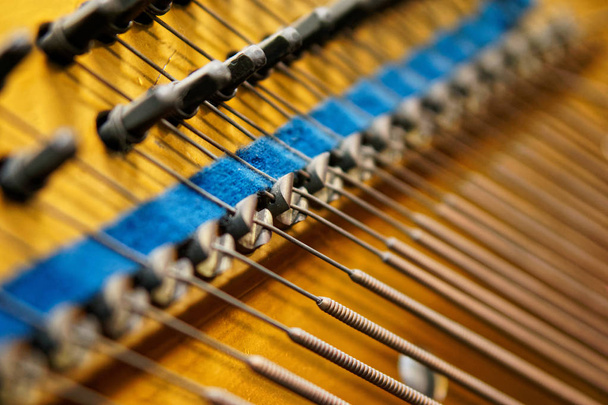 Haringen, demper en bas snaren binnen de oude piano. Het mechanisme van muziekinstrumenten. - Foto, afbeelding
